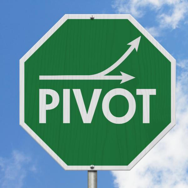 an octagon sign that is green with a white outline that shows two connecting arrows one going straight one going upward and below the arrows it says pivot