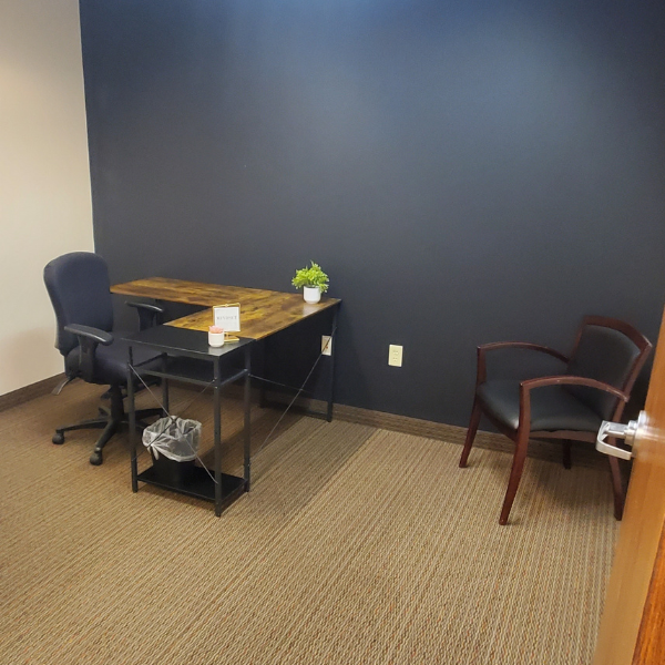 Office space with chair, desk, waste bin and executive chair